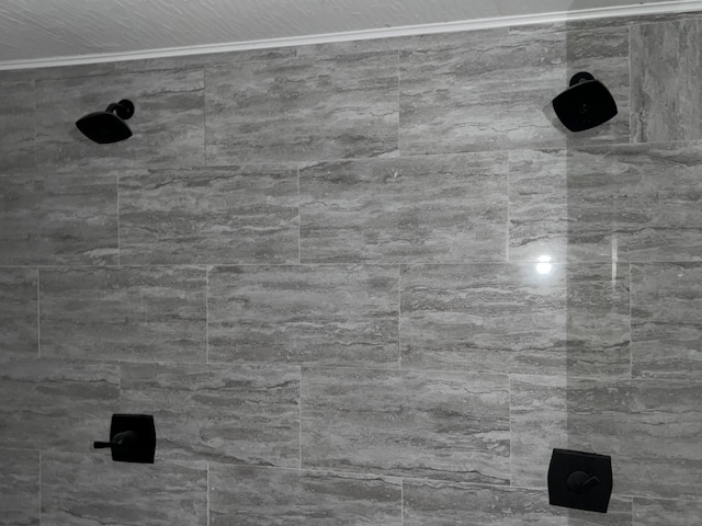 room details featuring a tile shower and crown molding