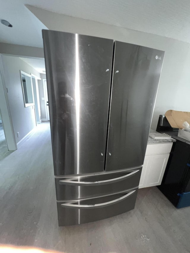 details with stainless steel fridge and hardwood / wood-style floors