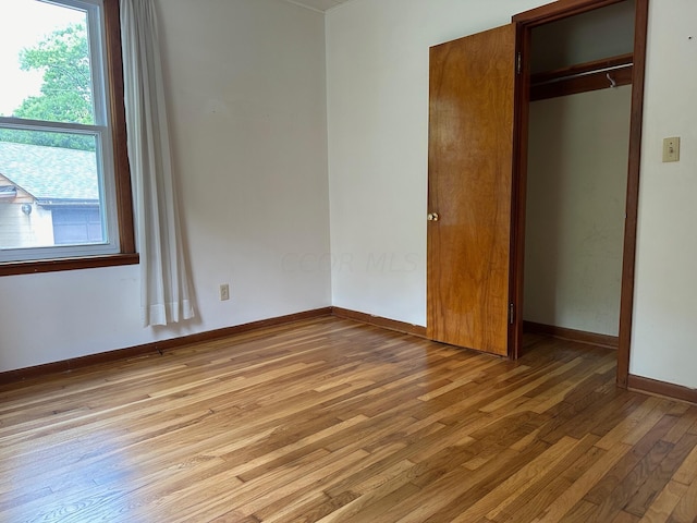 unfurnished bedroom with light hardwood / wood-style floors and a closet