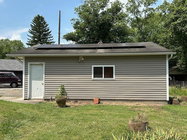 view of home's exterior with solar panels and a yard