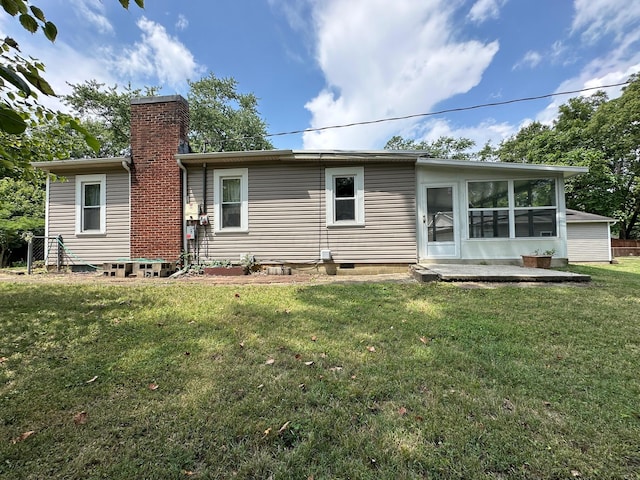 back of property with a sunroom and a yard