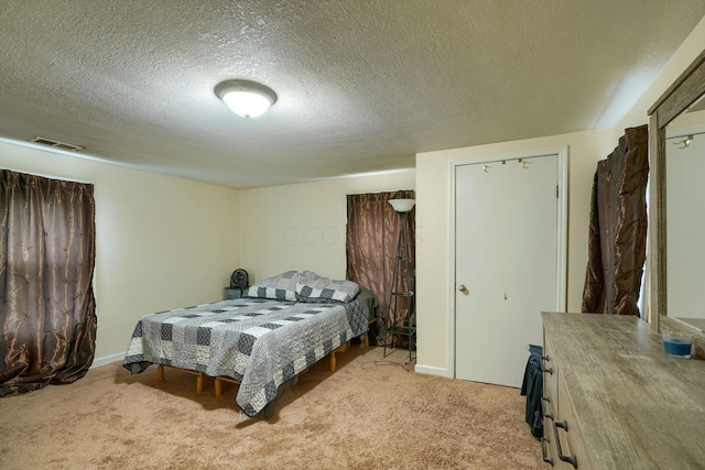 bedroom featuring light colored carpet and a textured ceiling