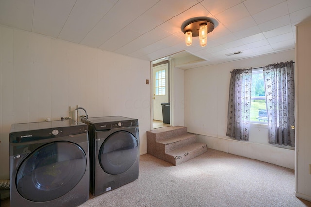 laundry room featuring light carpet and separate washer and dryer