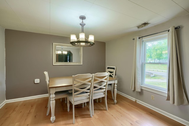 dining area with a chandelier and light wood-type flooring