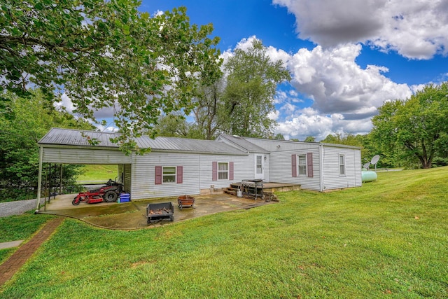 back of property with a yard and a carport