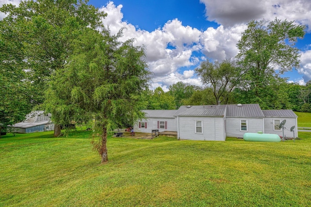 rear view of property with a yard