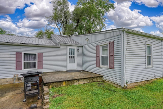 rear view of property featuring a lawn and a patio area