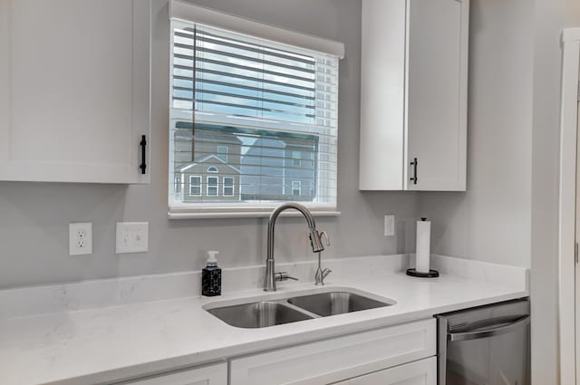 kitchen featuring dishwasher, white cabinetry, and sink