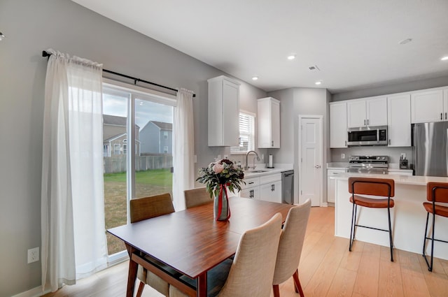 dining space featuring light hardwood / wood-style floors and sink