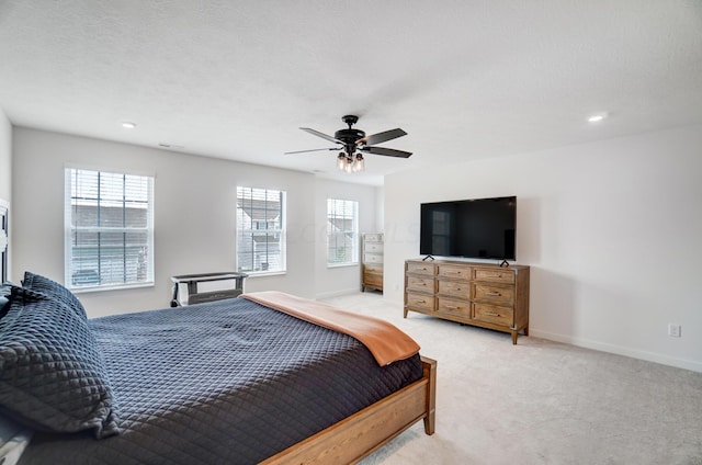 carpeted bedroom featuring ceiling fan and a textured ceiling