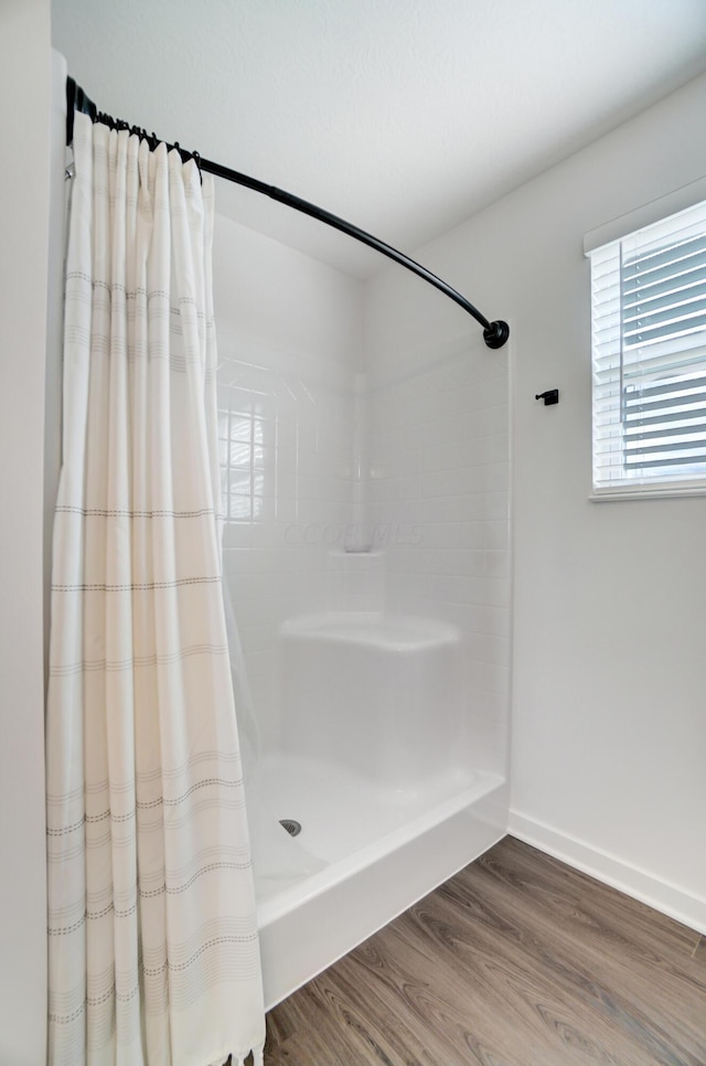 bathroom featuring hardwood / wood-style floors and walk in shower