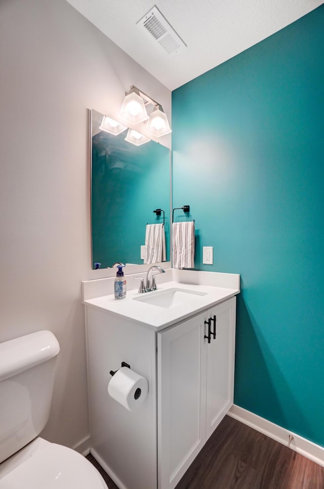 bathroom with vanity, wood-type flooring, and toilet