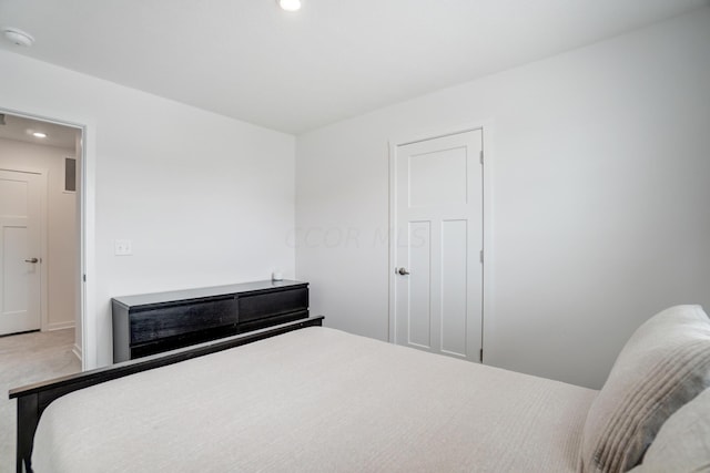 bedroom with carpet floors and a fireplace