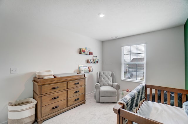 carpeted bedroom featuring a nursery area