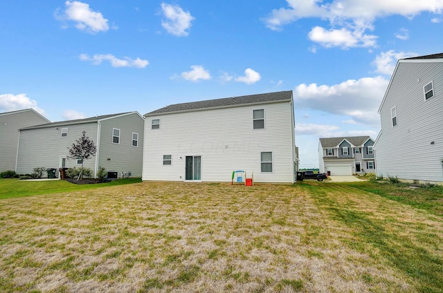 back of house with a yard, a garage, and central air condition unit