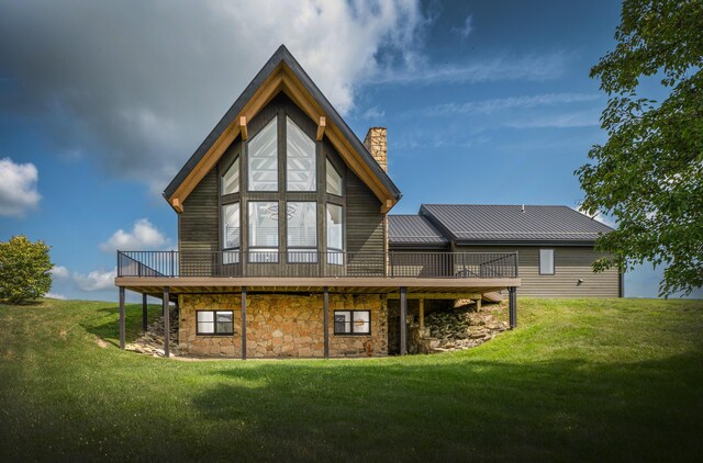 rear view of property featuring a lawn and a wooden deck