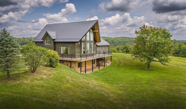 rear view of house featuring a lawn and a wooden deck