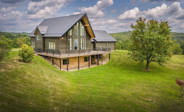 back of house featuring a lawn and a wooden deck