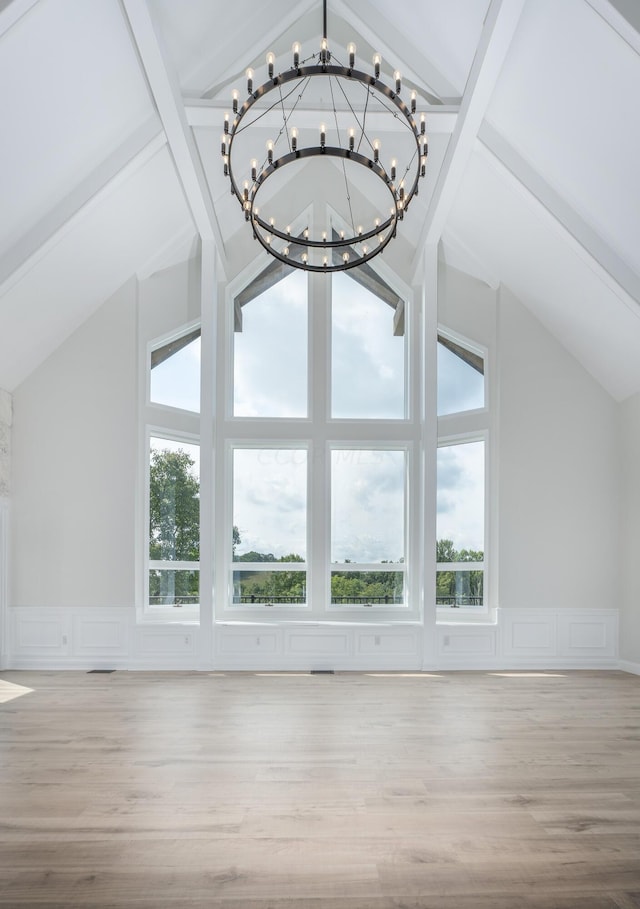 additional living space featuring beamed ceiling, high vaulted ceiling, light hardwood / wood-style flooring, and a notable chandelier