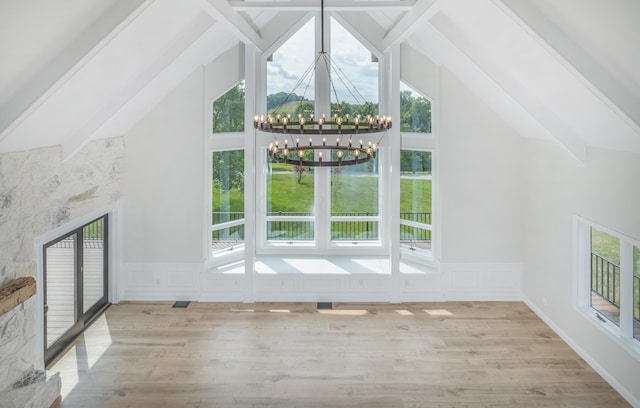 unfurnished living room featuring light hardwood / wood-style floors, plenty of natural light, and a notable chandelier