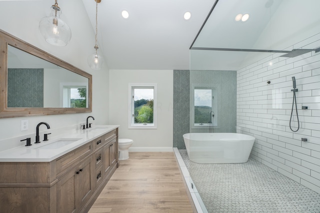 full bathroom with hardwood / wood-style flooring, vanity, shower with separate bathtub, and vaulted ceiling