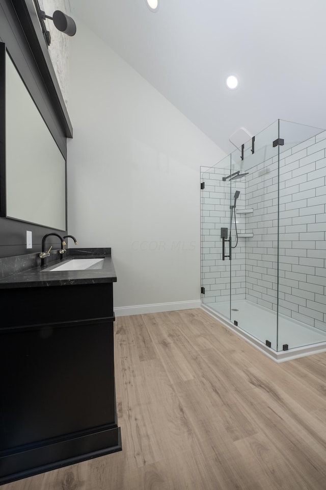 bathroom featuring hardwood / wood-style flooring, vanity, and walk in shower