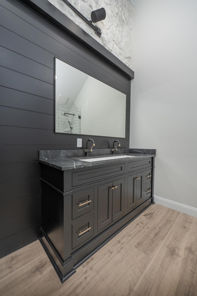 bathroom with vanity, wood-type flooring, lofted ceiling, and wooden walls