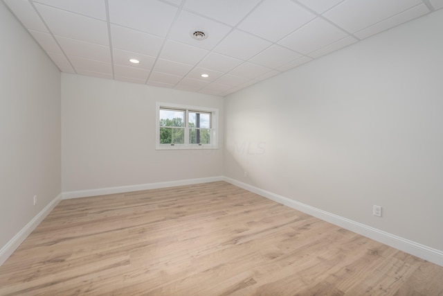 unfurnished room featuring a paneled ceiling and light hardwood / wood-style floors