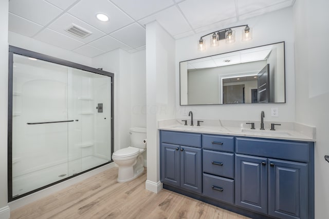 bathroom featuring a shower with shower door, toilet, wood-type flooring, and vanity