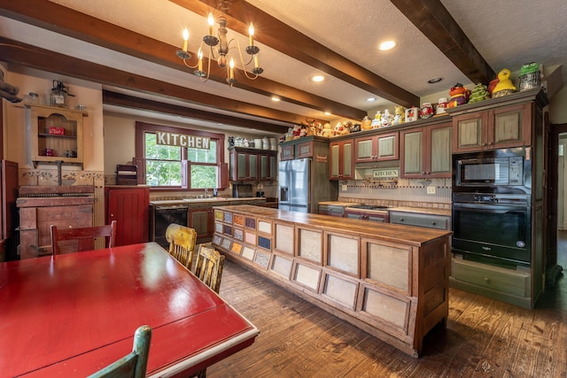 kitchen with beamed ceiling, dark hardwood / wood-style flooring, a chandelier, and black appliances