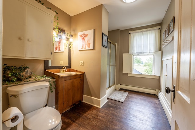 bathroom featuring vanity, a shower with door, toilet, a baseboard radiator, and wood-type flooring