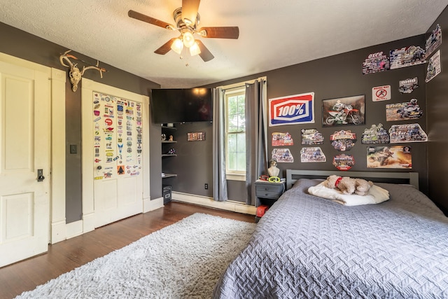 bedroom with ceiling fan, dark hardwood / wood-style flooring, a textured ceiling, and a baseboard radiator