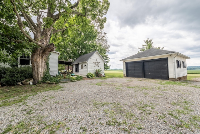 view of yard with a garage and an outbuilding