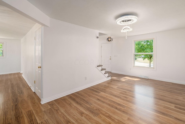 unfurnished room featuring hardwood / wood-style floors and lofted ceiling