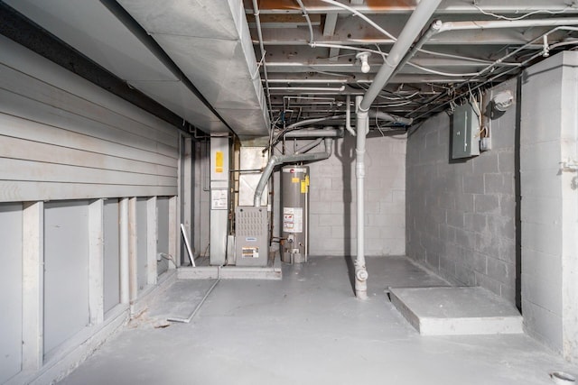 basement featuring electric panel, heating unit, and gas water heater