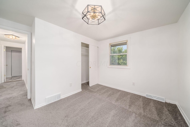 unfurnished bedroom featuring light colored carpet and a closet