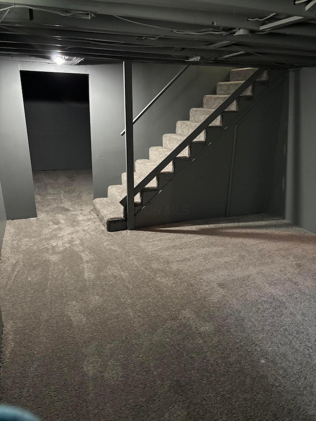 finished basement featuring carpet flooring and stairway
