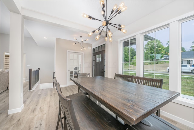 dining space featuring light hardwood / wood-style floors, an inviting chandelier, and a wealth of natural light