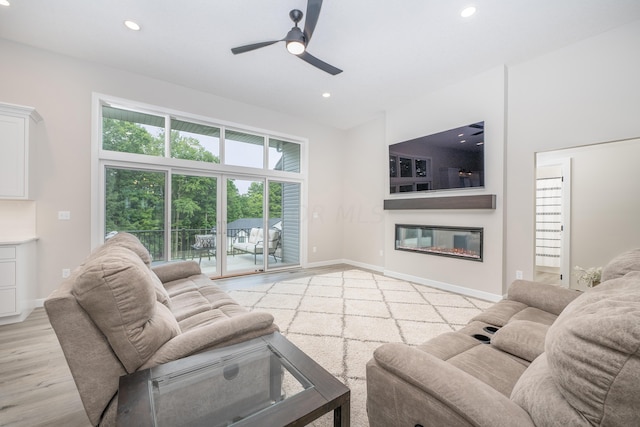 living room with light hardwood / wood-style flooring and ceiling fan