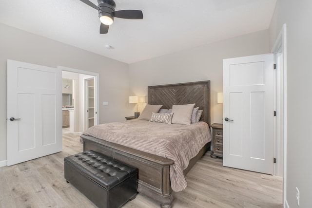 bedroom featuring ceiling fan, light hardwood / wood-style floors, and a walk in closet