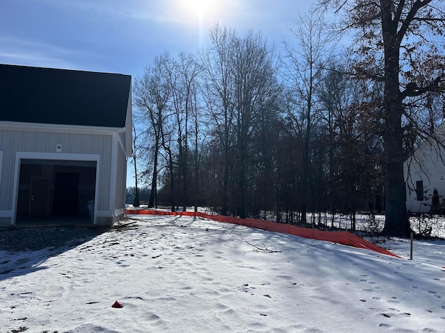 snowy yard featuring a garage