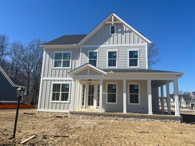 view of front of property with covered porch, board and batten siding, and roof with shingles