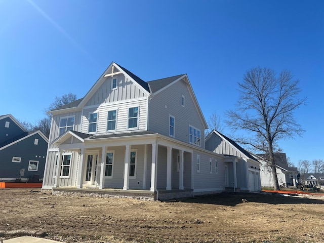 view of front facade with a garage, board and batten siding, and covered porch