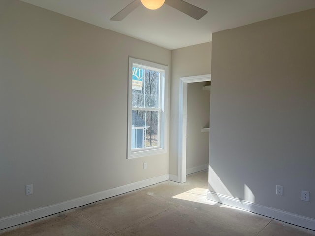 unfurnished bedroom featuring ceiling fan, concrete flooring, and baseboards