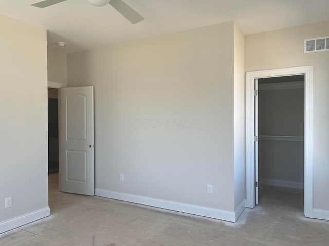 unfurnished bedroom featuring a spacious closet, a ceiling fan, visible vents, and baseboards