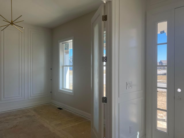 entryway with baseboards and concrete flooring