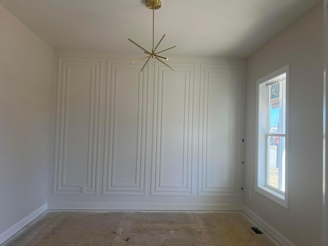 empty room featuring unfinished concrete flooring, visible vents, and baseboards