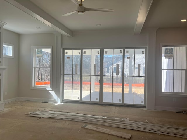 interior space with a ceiling fan, beamed ceiling, and baseboards