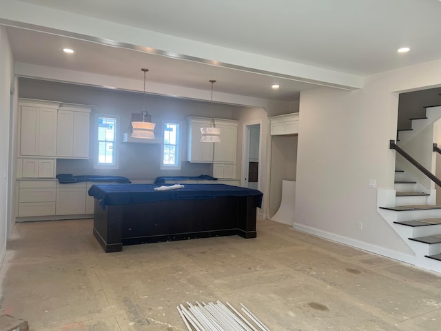 kitchen featuring recessed lighting, white cabinetry, a kitchen island, and baseboards