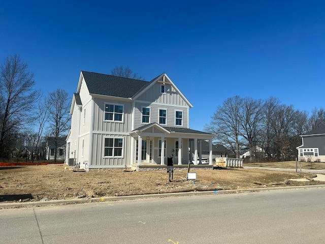 view of front of house with board and batten siding, central AC, and a porch